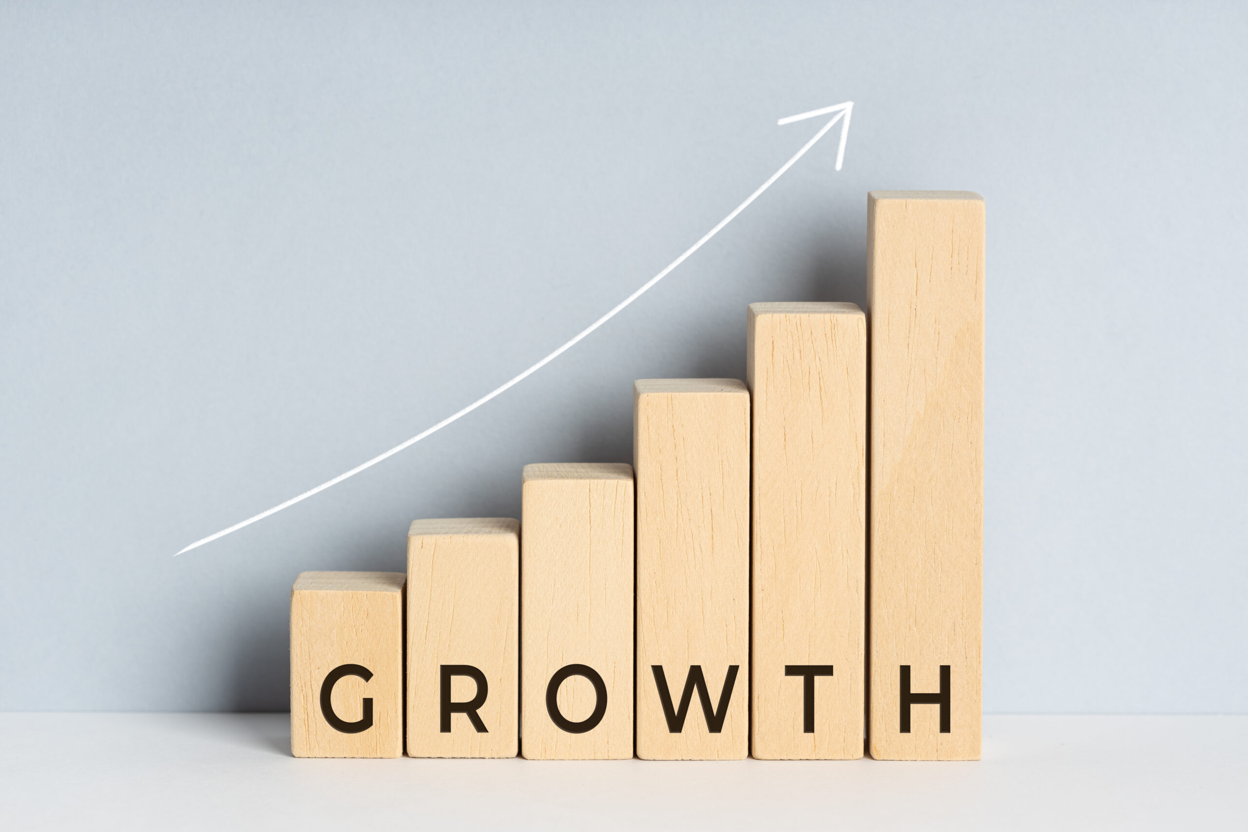 Growth concept. Wooden block bar chart graph with text and upward trend line drawn on background. Copy space